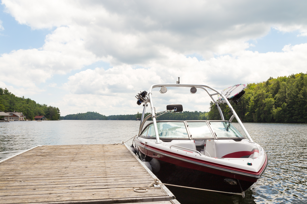 wakeboarding boat tied to a wooden dock